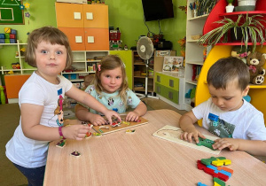 Dzieci układają układanki przy stoliku.