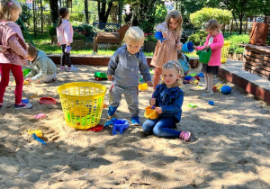 Dzieci bawią się w piaskownicy.