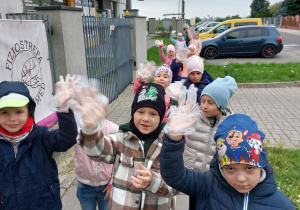Dzieci prezentują akcesoria niezbędne do uczestnictwa w akcji Sprzątanie Świata