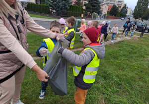 Dzieci wrzucają śmieci do worka