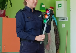 Policjant pokazuje dzieciom sygnalizator świetlny
