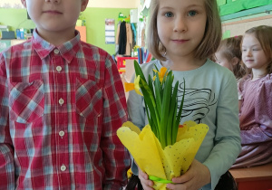 Chłopcy wręczają kwiatki dziewczynką