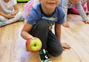 Ignaś pokazuje dzieciom jabłko