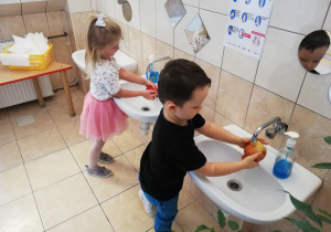 Chłopiec i dziewczynka myją jabłka w łazience