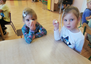 Dwie dziewczynki jedzą jabłko