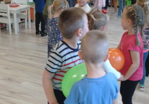 Dzieci z grupy VI tańczą w parach trzymając balony brzuszkami.