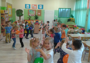 Dzieci z grupy VI tańczą w parach trzymając balony brzuszkami i podnoszą ręce do góry.