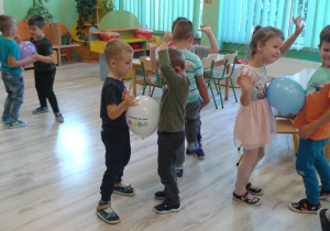 Dzieci z grupy VI tańczą w parach z balonami. Mają uśmiechnięte minki.