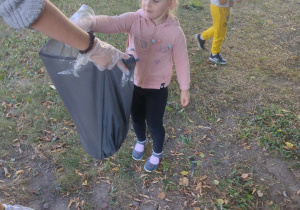 Dziecko wrzuca śmieci do worka