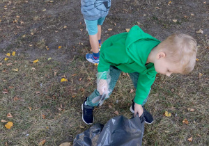 Dziecko wrzuca śmieci do worka