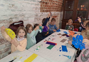 Dzieci na zamku biorą udział w warsztatach z tworzenia wycinanki