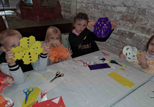 Dzieci na zamku biorą udział w warsztatach z tworzenia wycinanki