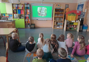 Dzieci oglądają prezentację multimedialną poświęconą gatunkom i rodzajom drzew