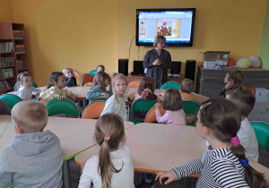 Dzieci oglądają prezentację dotyczącą jesieni i słuchają historii o listku