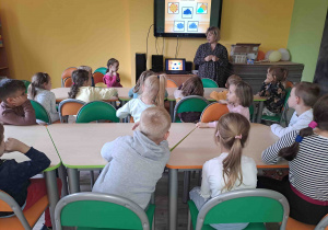 Dzieci oglądają prezentację dotyczącą jesieni i słuchają historii o listku