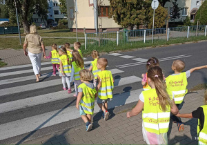 Dzieci przechodzą przez ulicę w wyznaczonym do tego miejscu