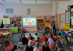 Dzieci oglądają prezentację dotyczącą gatunków dyni