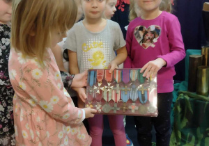 Dzieci trzymają medale żołnierskie