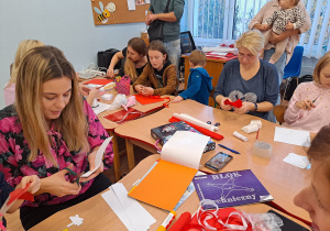 Rodzice przy stolikach pracują z dziećmi