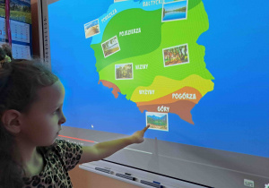Dzieci wykonują ćwiczenia na tablicy interaktywnej - uzupełniają mapę Polski