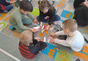 Dzieci składają w całość godło Polski z małych elementów
