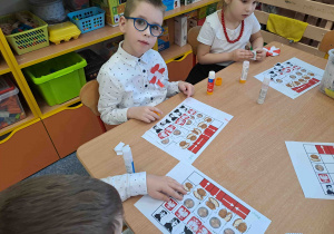 Dzieci wykonują ćwiczenia z kodowania z elementami symboli narodowych