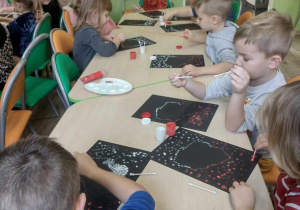 Dzieci przy stoliku wykonują kontur Polski