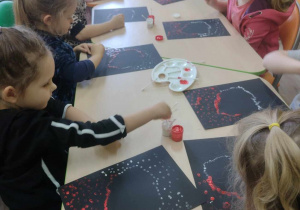 Dzieci przy stoliku wykonują kontur Polski