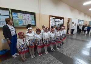 Dzieci stoją na baczność i śpiewają Hymn Polski