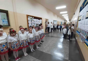 Dzieci i nauczycielki stoją na baczność i śpiewają Hymn Polski