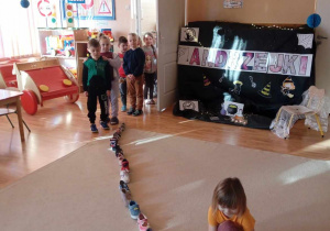 Dzieci układają buty, by sprawdzić, komu spełni się andrzejkowa wróżba.