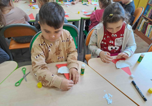 Dzieci wykonują pracę plastyczną - Mikołaja z papierowego talerzyka