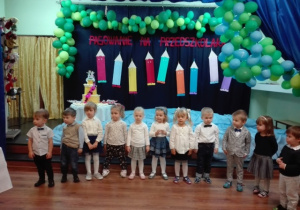 Dzieci z grupy I występują na sali teatralnej na tle dekoracji z okazji uroczystości - Pasowanie na Przedszkolaka