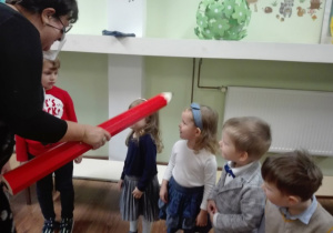 Pani Dyrektor pasuje dzieci za pomocą " czarodziejskiego ołówka" na przedszkolaka
