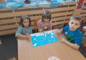 Dzieci przy malowaniu zimowego pejzażu