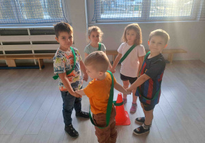 Dzieci zbierają się w grupach wokół pachołków z przypisanym im kolorem szarfy