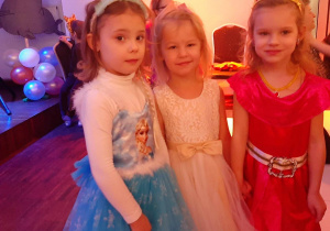 Trzy dziewczynki przebrane za księżniczki na balu karnawałowym.