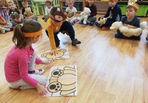 Dziewczynka z chłopcem układają obrazkowe puzzle przedstawiające misia