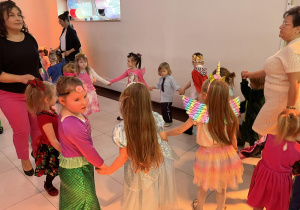 Dzieci tańczą w kółeczku trzymając się za ręce