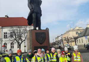 Dzieci pozują do zdjęcia przy pomniku Józefa Piłsudskiego.