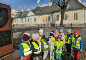 Dzieci pozują do zdjęcia na chodniku. W tle widać Pałac Saski.