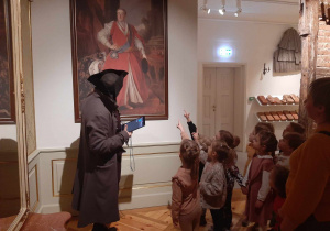Dzieci zwiedzają komnaty w Muzeum w Kutnie. Stoją przed obrazem Króla Augusta.