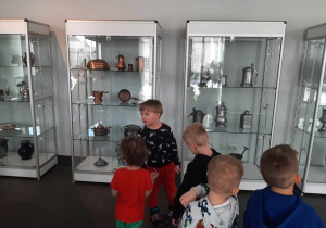 Przedszkolaki oglądały eksponaty zastawy kuchennej z dawnych epok.
