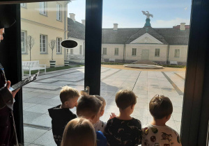 Chłopcy patrzą przez szybę na dziedziniec Pałacu Saskiego.