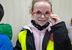 Dzieci przymierzają okulary służące do dokonywania korekcji wzroku