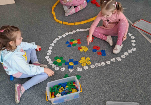 Dzieci na podłodze układają gigantyczne pisanki z klocków