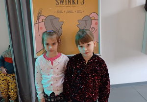 Oliwia i Lena na tle afisza teatralnego