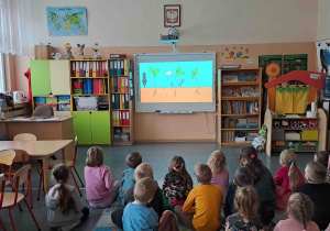 Dzieci oglądają film edukacyjny "Co potrzebują rośliny do wzrostu"