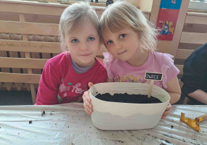 Dzieci prezentują doniczki z nazwami posadzonych roślin