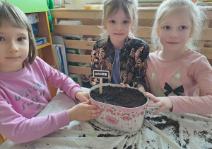Dzieci prezentują doniczki z nazwami posadzonych roślin